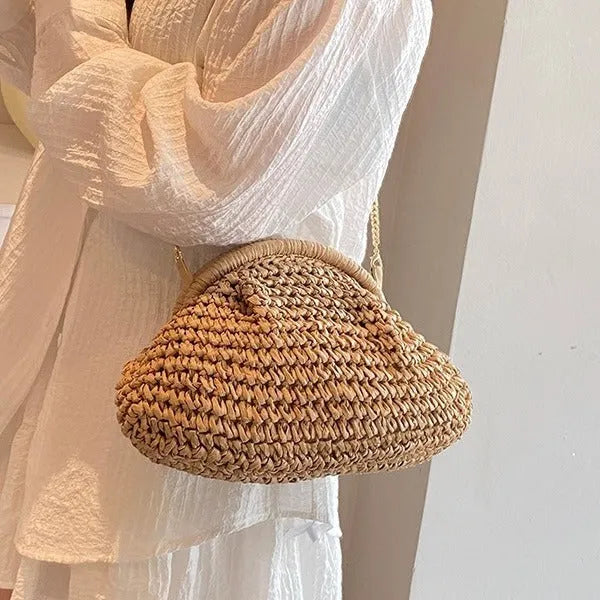 Beige shell-shaped straw shoulder bag with chain strap and woven texture.