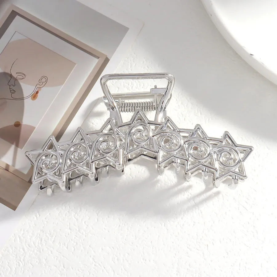 Silver metal hair claw clip assortment showing bows, waves, pearl designs, and geometric shapes from 4cm to 13.5cm