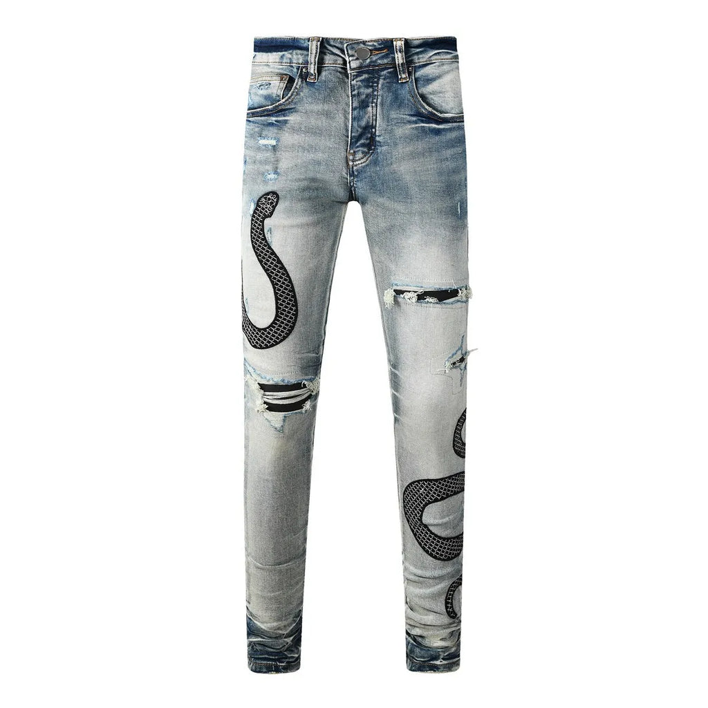 Man's blue distressed skinny jeans with a button fly and mid waist on a grey background.