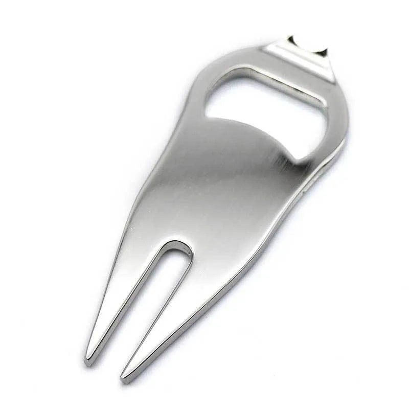 Black zinc alloy golf ball fork and bottle opener tool on green turf