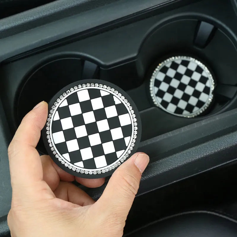 Black and white checkerboard pattern PVC car cup holder mat inserted in a vehicle centre console.