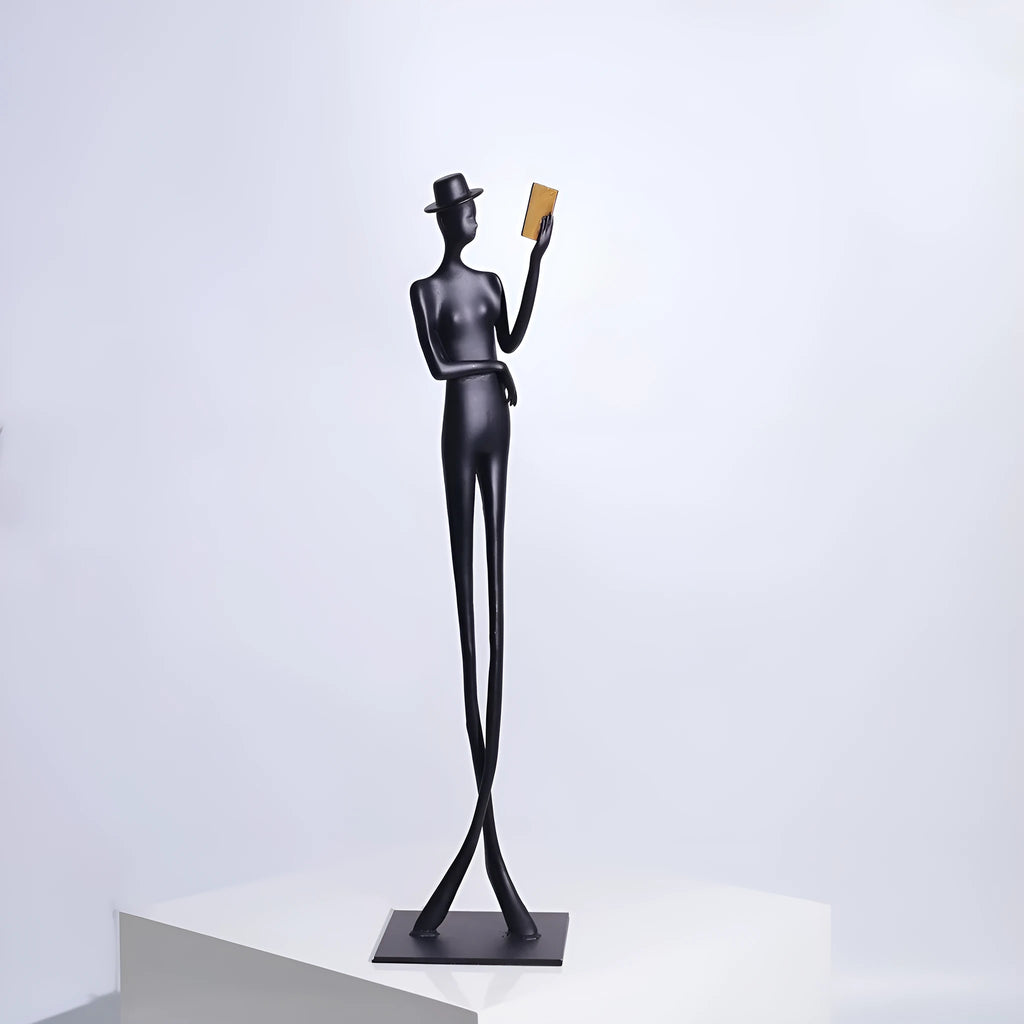 Black metal desktop sculpture of a woman reading, 51cm tall.