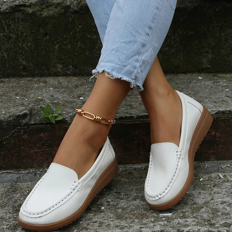 Women's PU leather slip-on loafers in round toe flat heel design showing car suture detailing