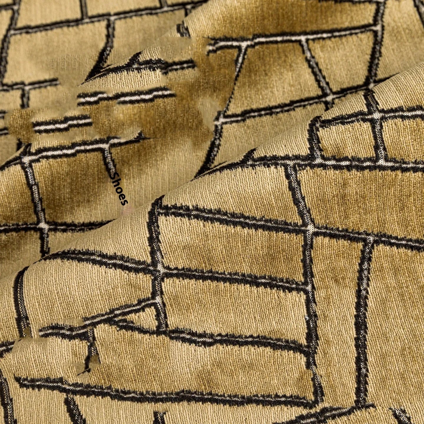Geometric abstract pattern decorative pillow case in gold colour on a grey sofa.