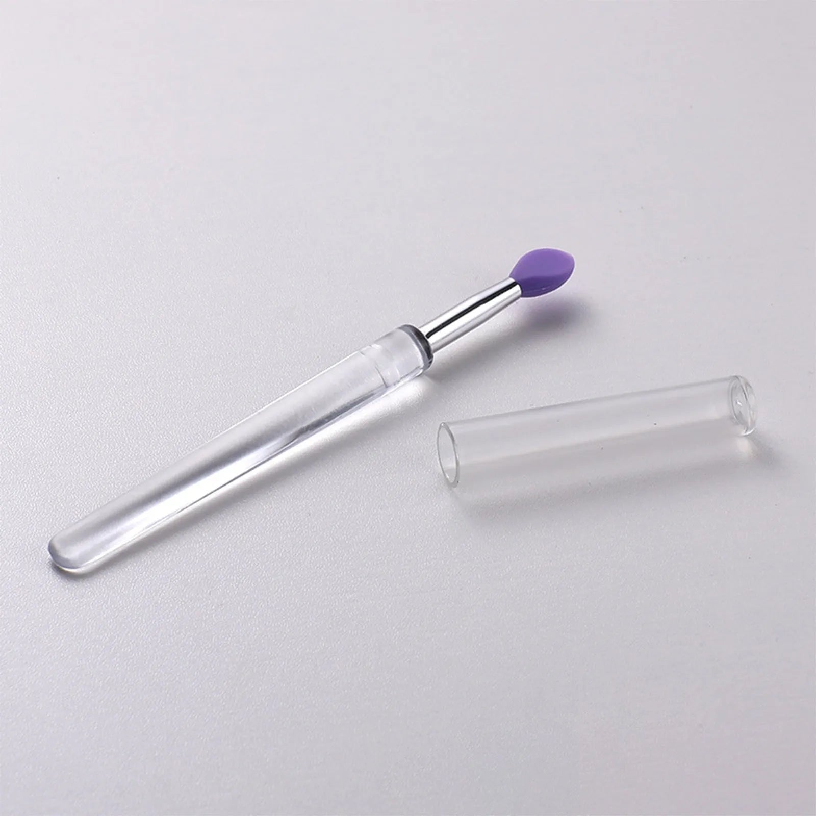 A reusable silicone lip brush with a handle and protective cap, shown in one of eight available colours.