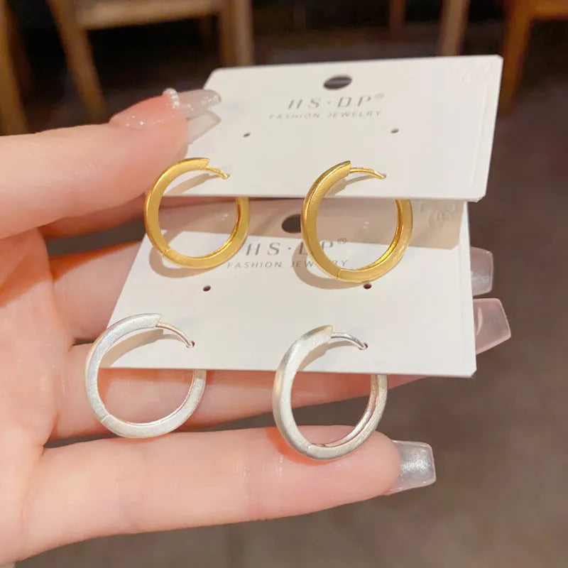 Women's geometric eyelet ear clip in gold or silver colour with round elements on copper base