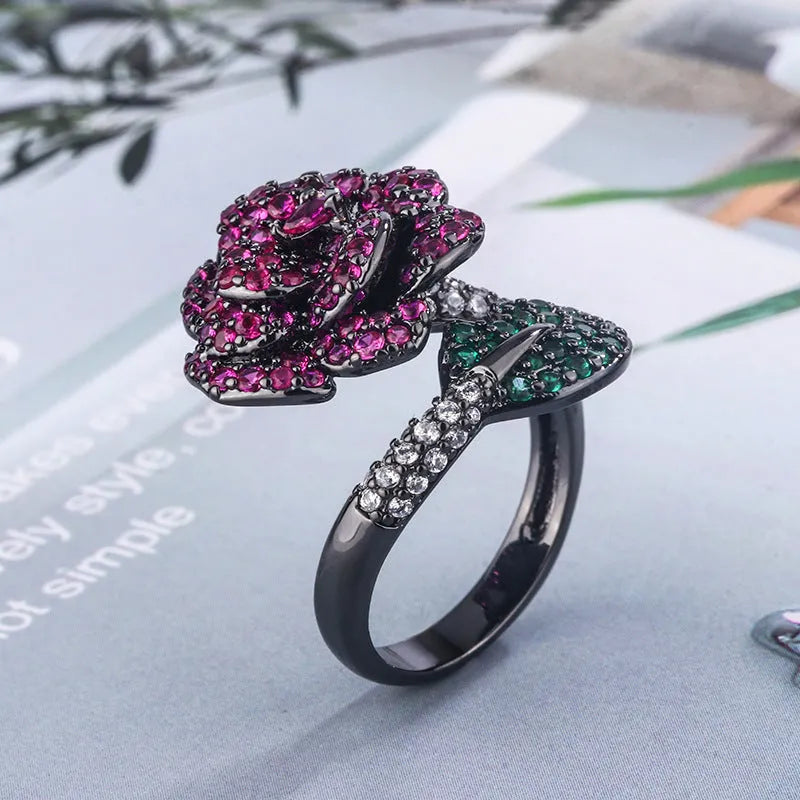 Geometric black gold flower ring with simulation red corundum centrepiece on female hand