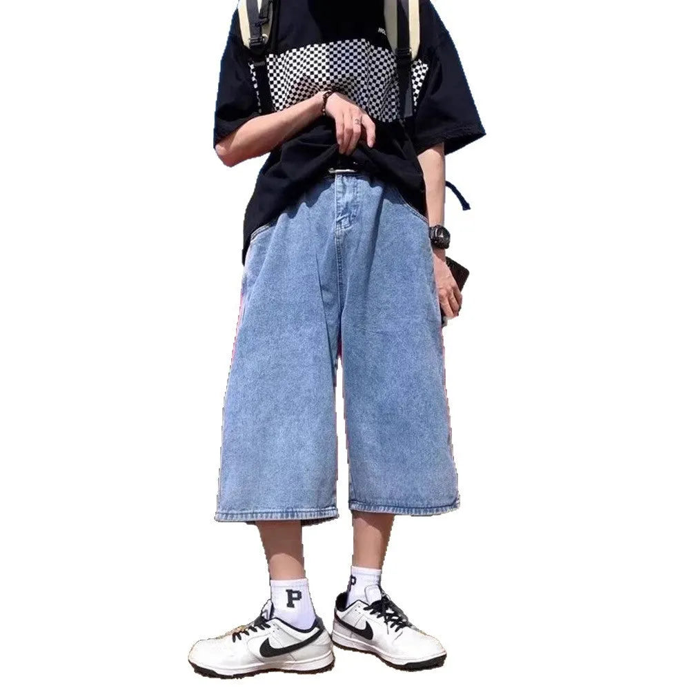 Man wearing blue washed denim shorts with a high waist, cropped leg, and straight cut.