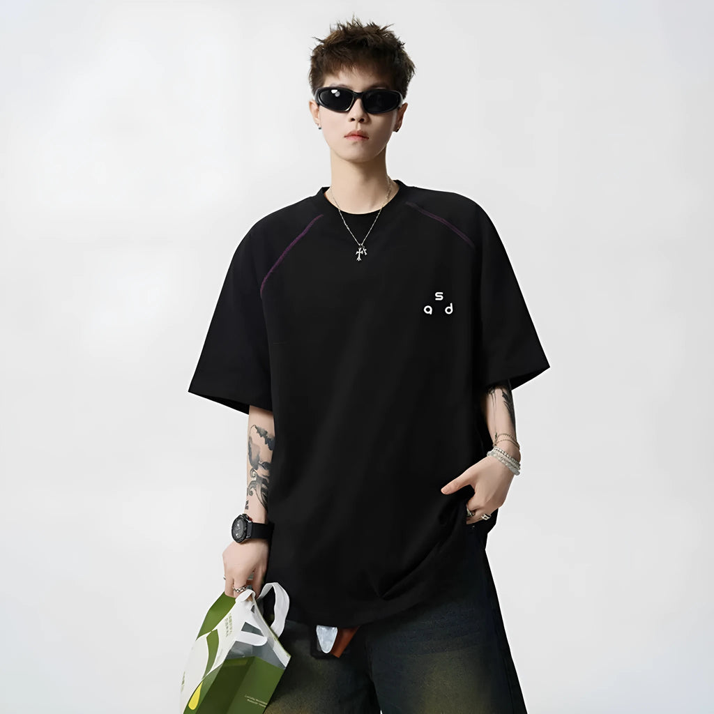 A loose-fitting black cotton short-sleeve T-shirt with a round neck on a hanger.
