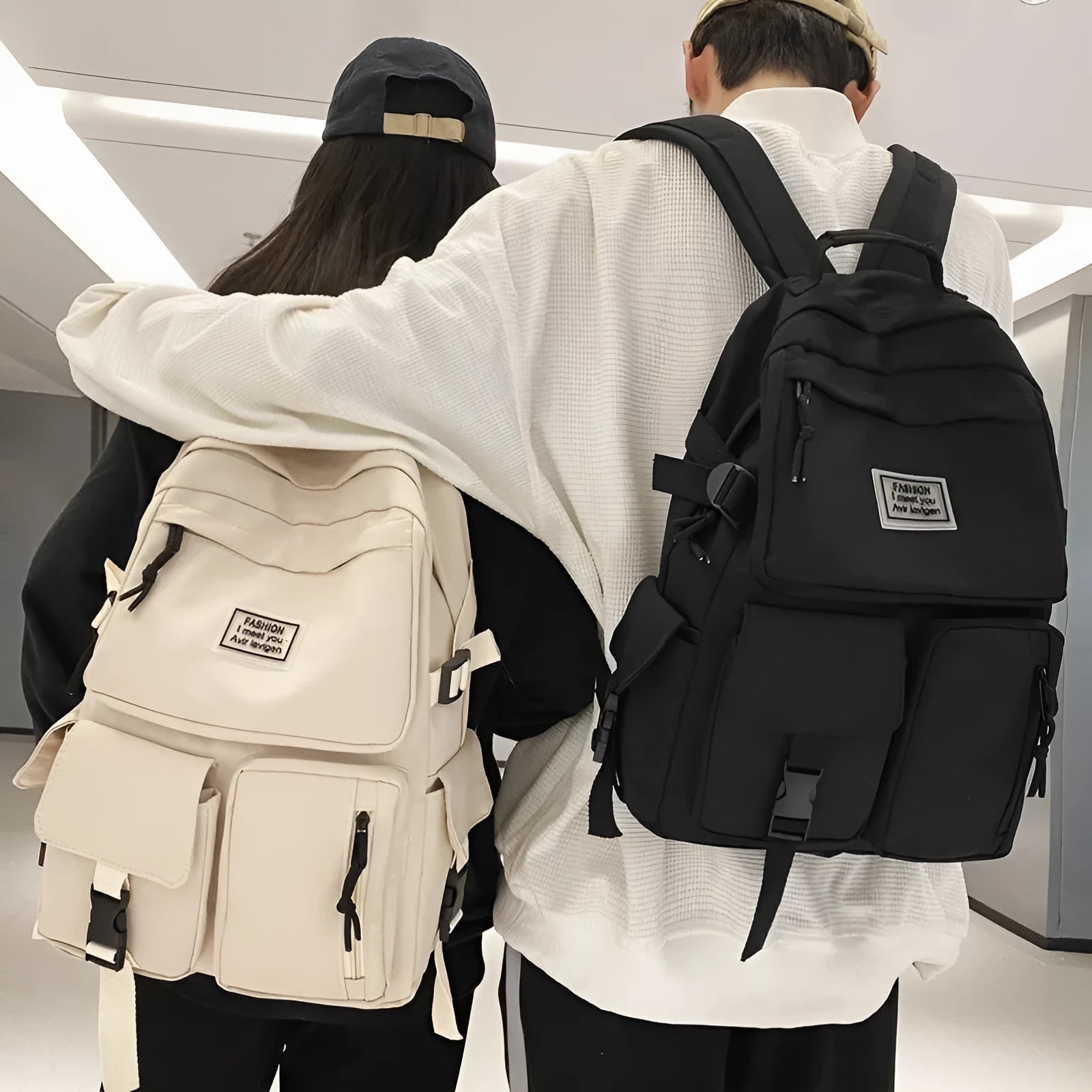 Black and white nylon student backpack with front 3D pockets, shown with laptop in compartment.