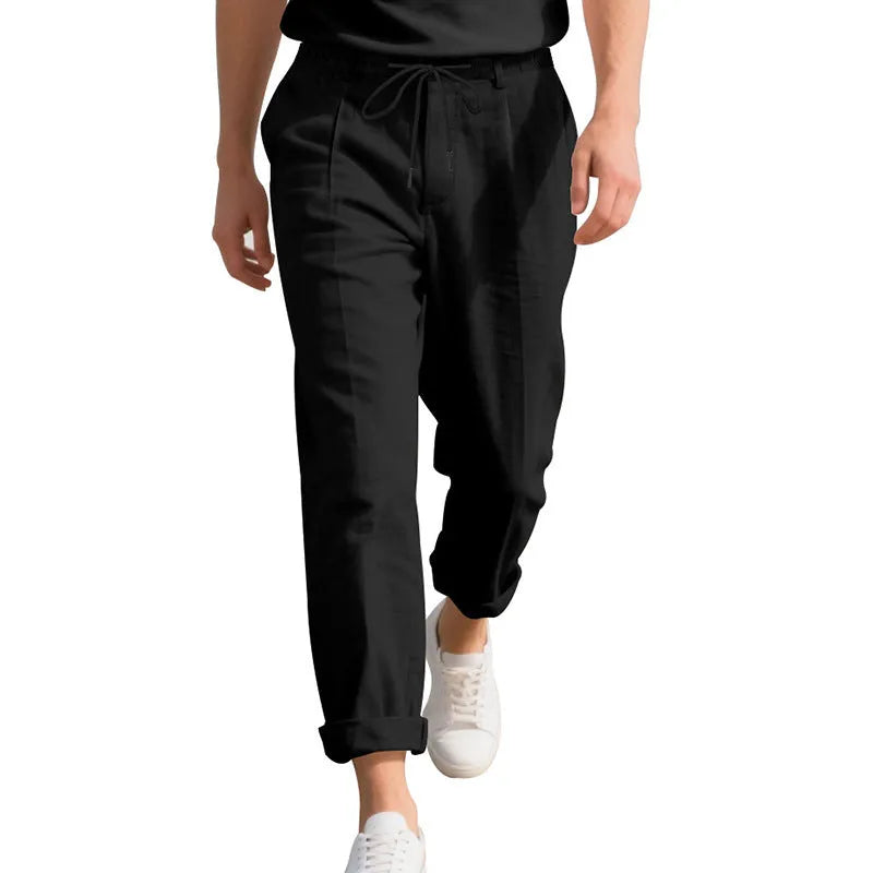 Men's straight leg linen trousers in light khaki colour with drawstring waist, laid flat.