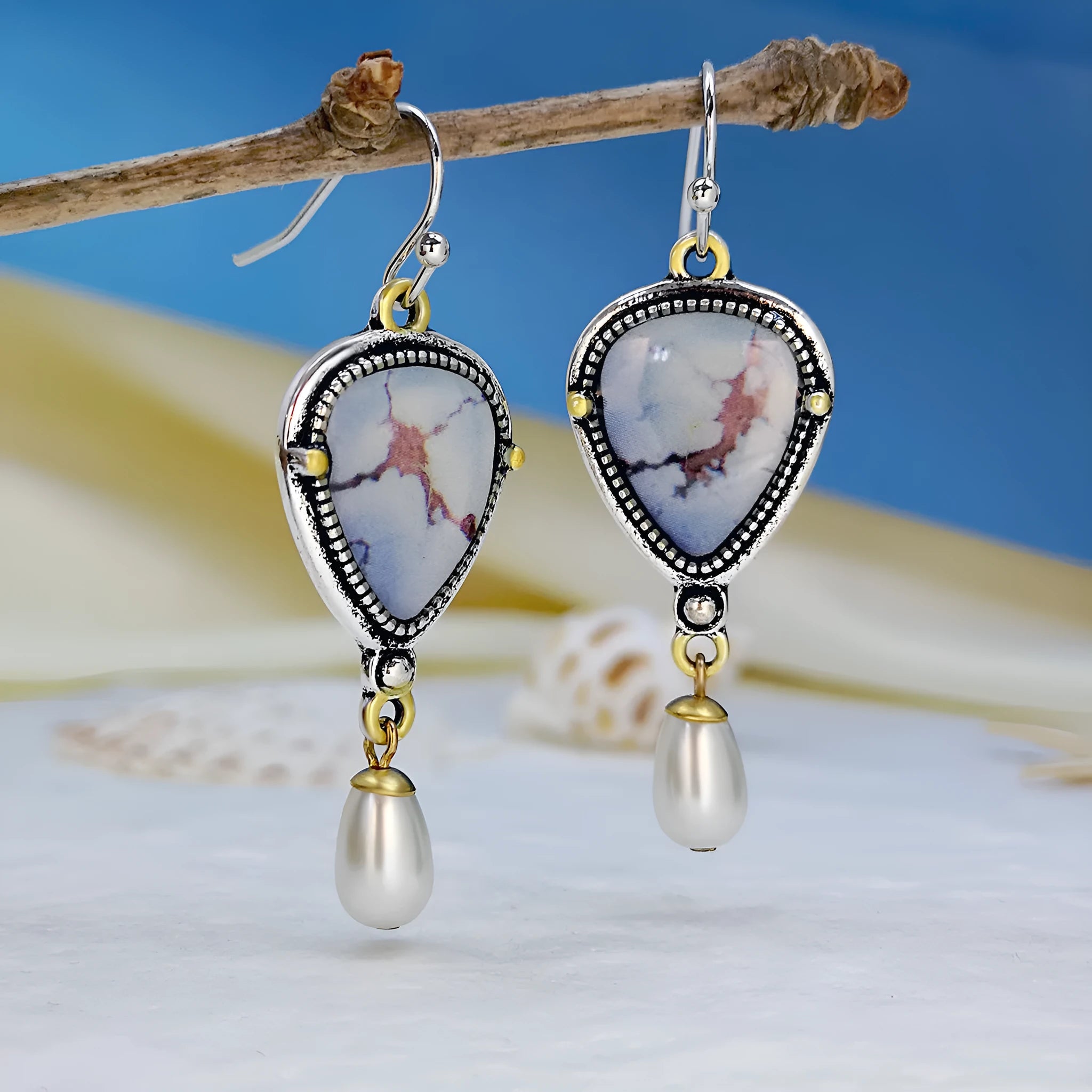 Retro blue geometric drop earrings with synthetic opal and pearl details on a two-tone electroplated metal setting.