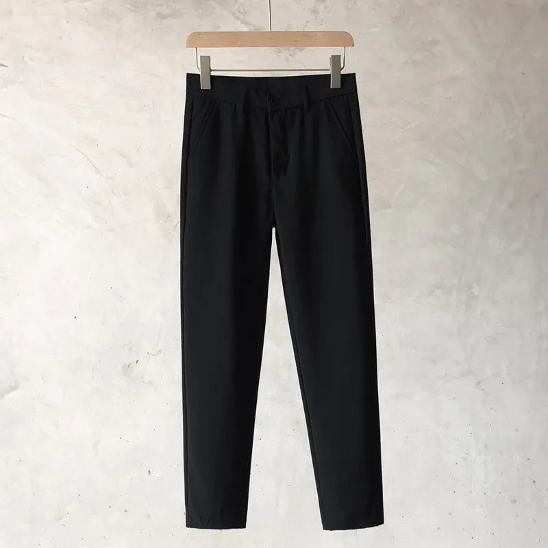 Boy wearing slim straight wool trousers in a neutral colour, showcasing the tapered fit and straight leg opening.