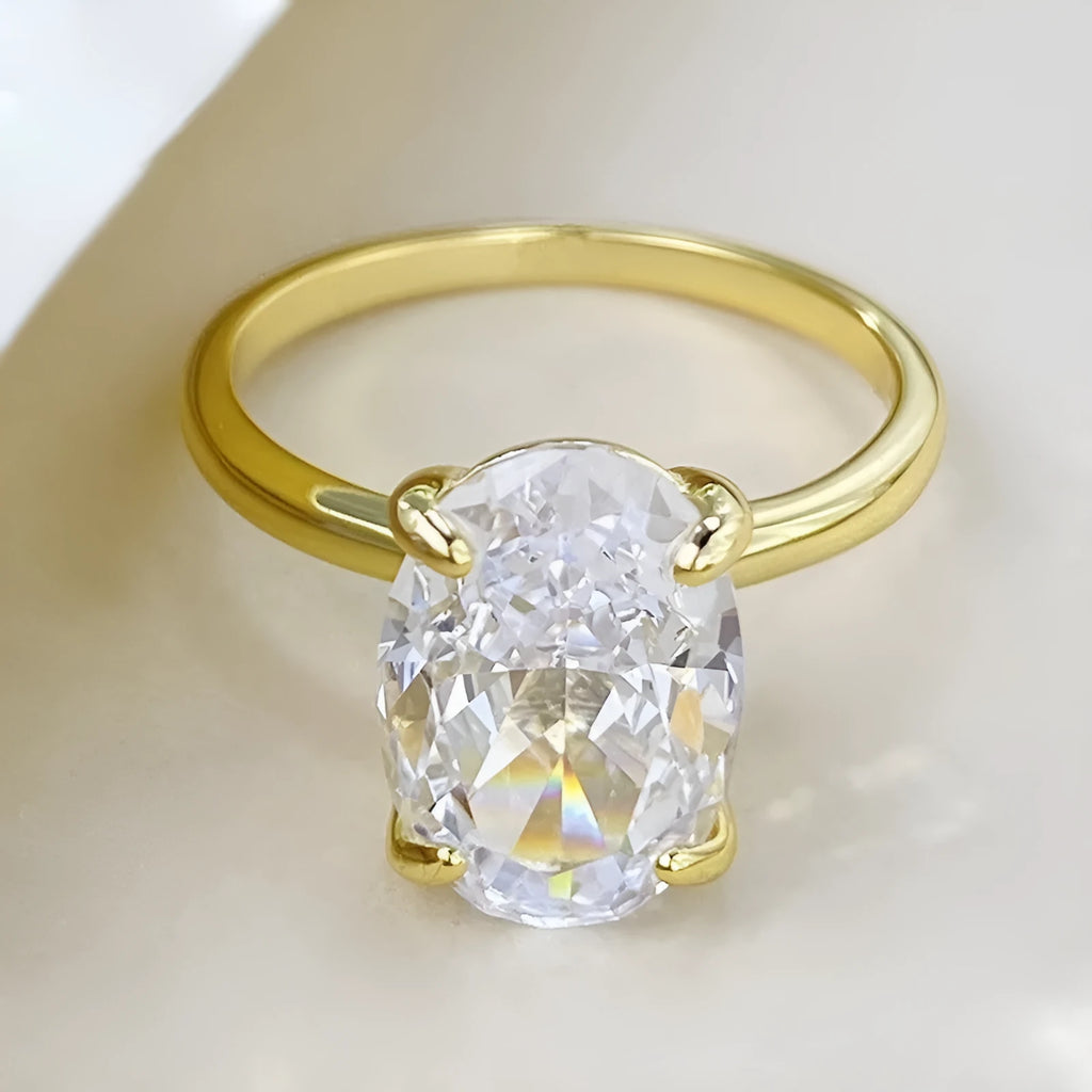 Oval women's ring with four-claw setting holding 6x9mm gemstone in gold or silver finish