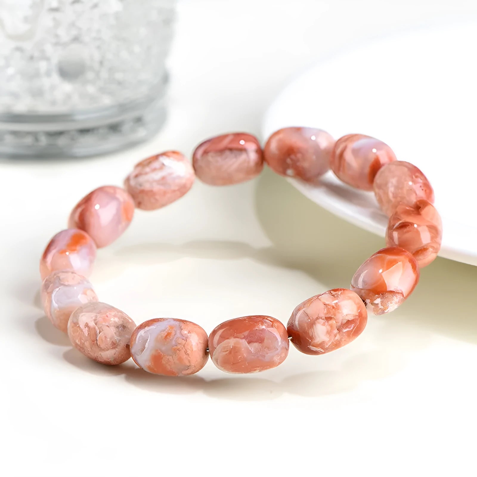 Natural cherry agate bracelet with barrel-shaped beads showing geometric design and Ruyi patterns