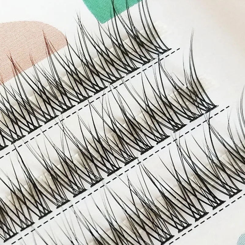 Black V-shaped fishtail false eyelashes showing thick segment design on a clear band.