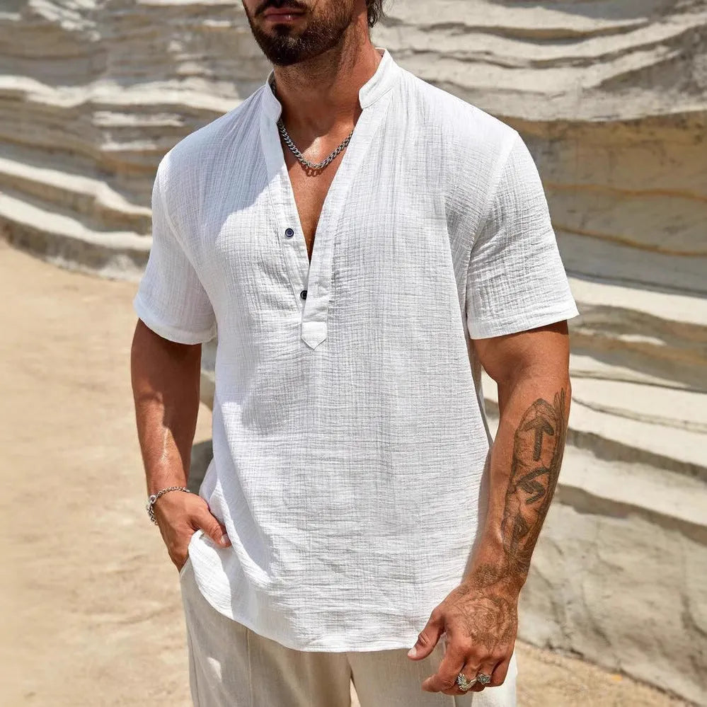 Man wearing a solid colour short-sleeve shirt with a stand collar in a casual setting.