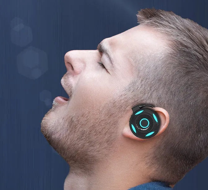 Black and white Bluetooth wireless earphones with hanging over-ear design showing USB charging port