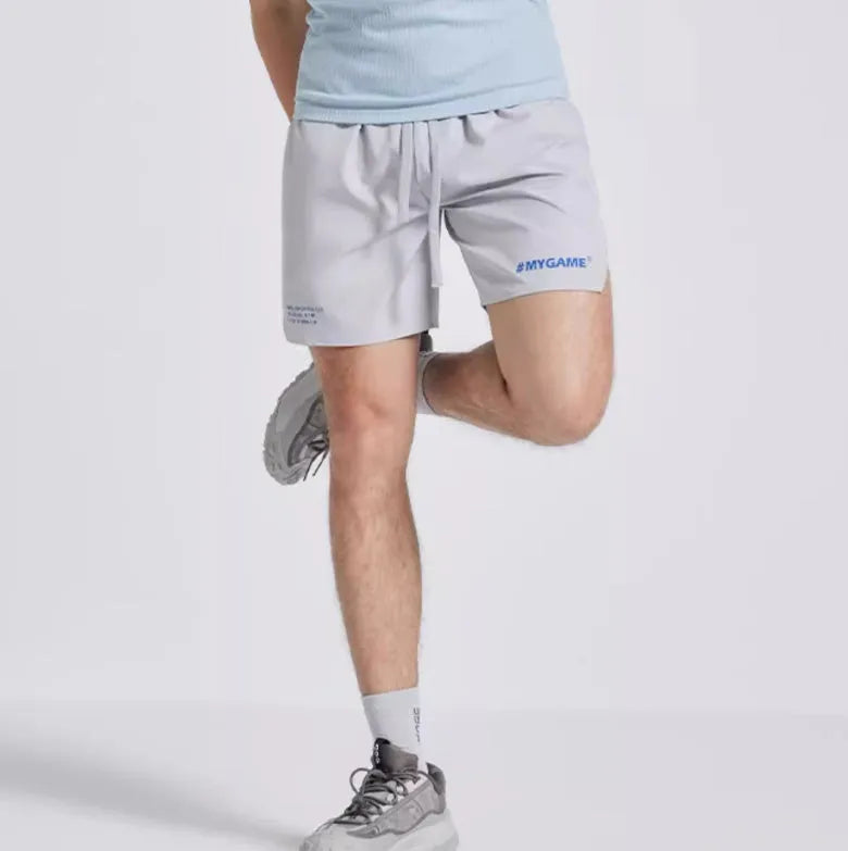 Men's training shorts in black, blue, grey, and white colours from a front view.