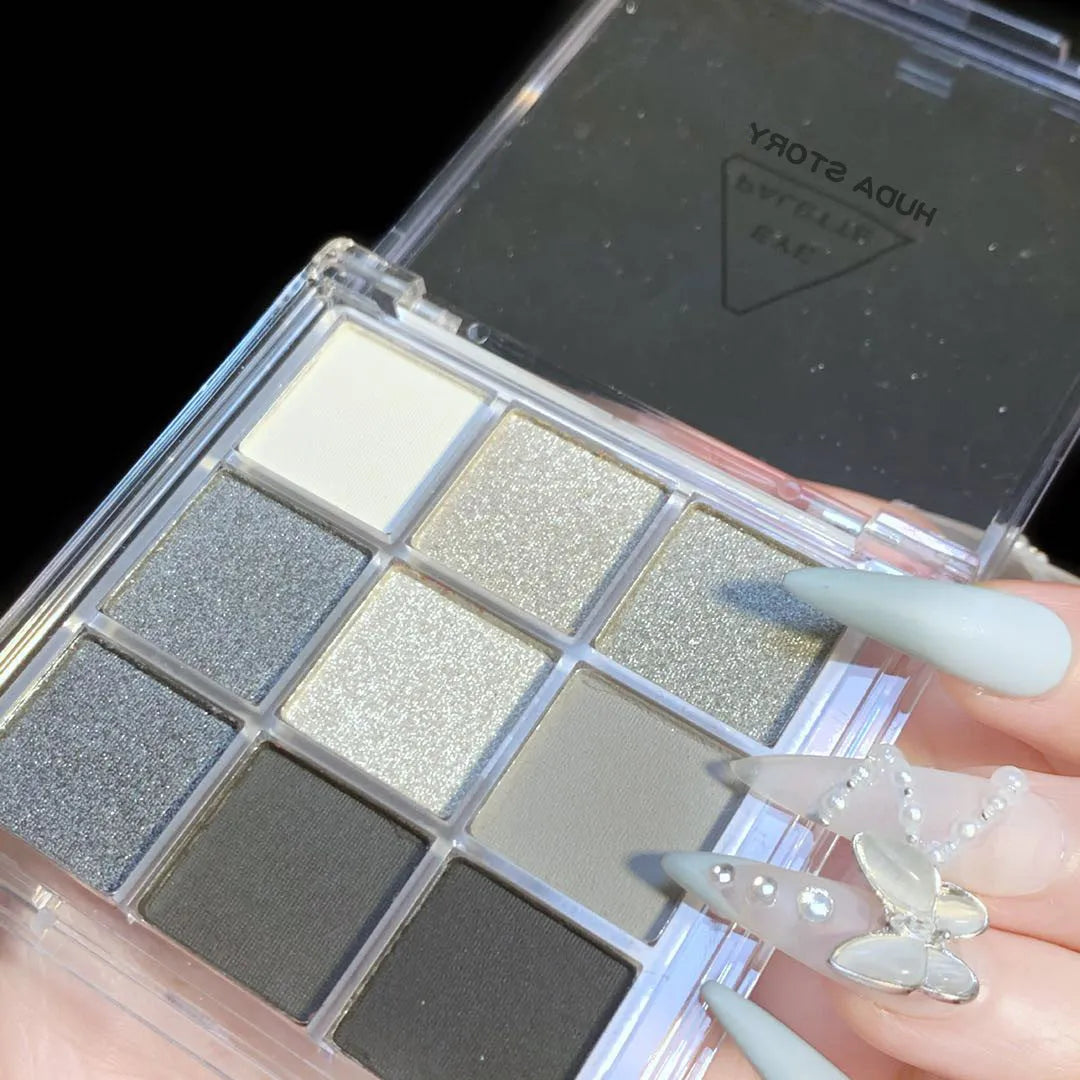 Nine-colour smoked eyeshadow palette showing white, silver, black, and iron grey shades in compact case
