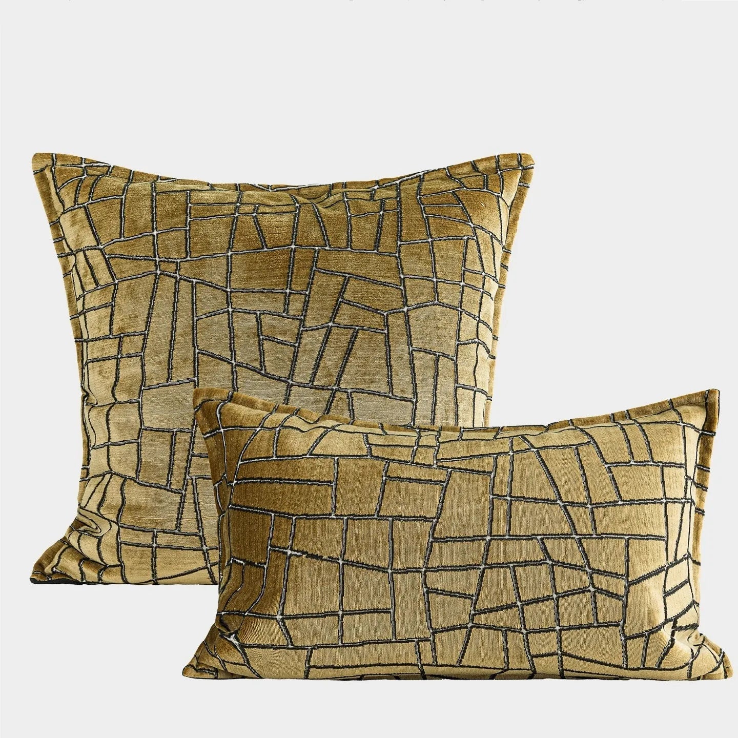 Geometric abstract pattern decorative pillow case in gold colour on a grey sofa.