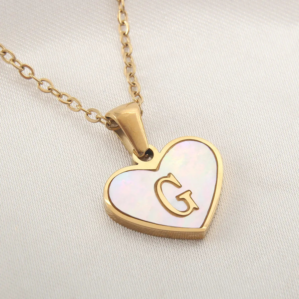 Gold plated heart-shaped necklace with white shell pendant on adjustable stainless steel chain