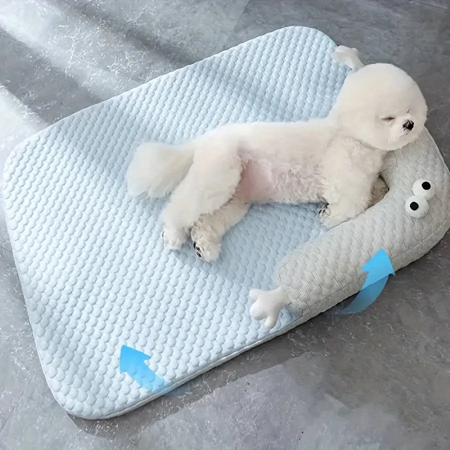 Blue polyester pet bed cushion with printed big-eyed monster face design, shown on a wooden floor.