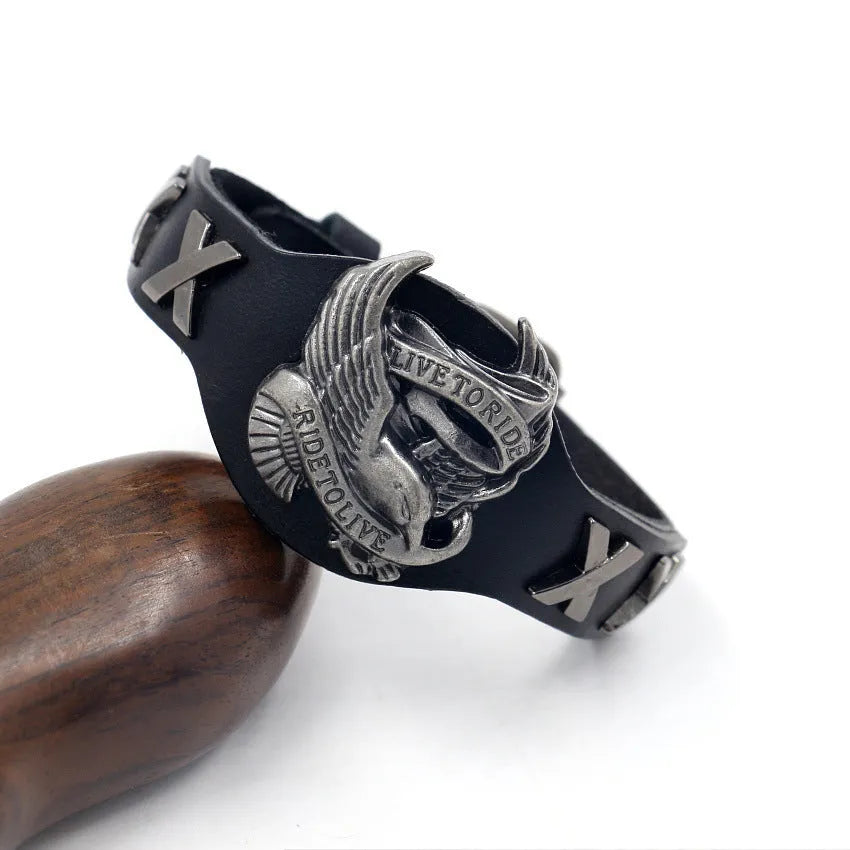 Black geometric leather bracelet with a silver watch-button clasp on a unisex wrist.