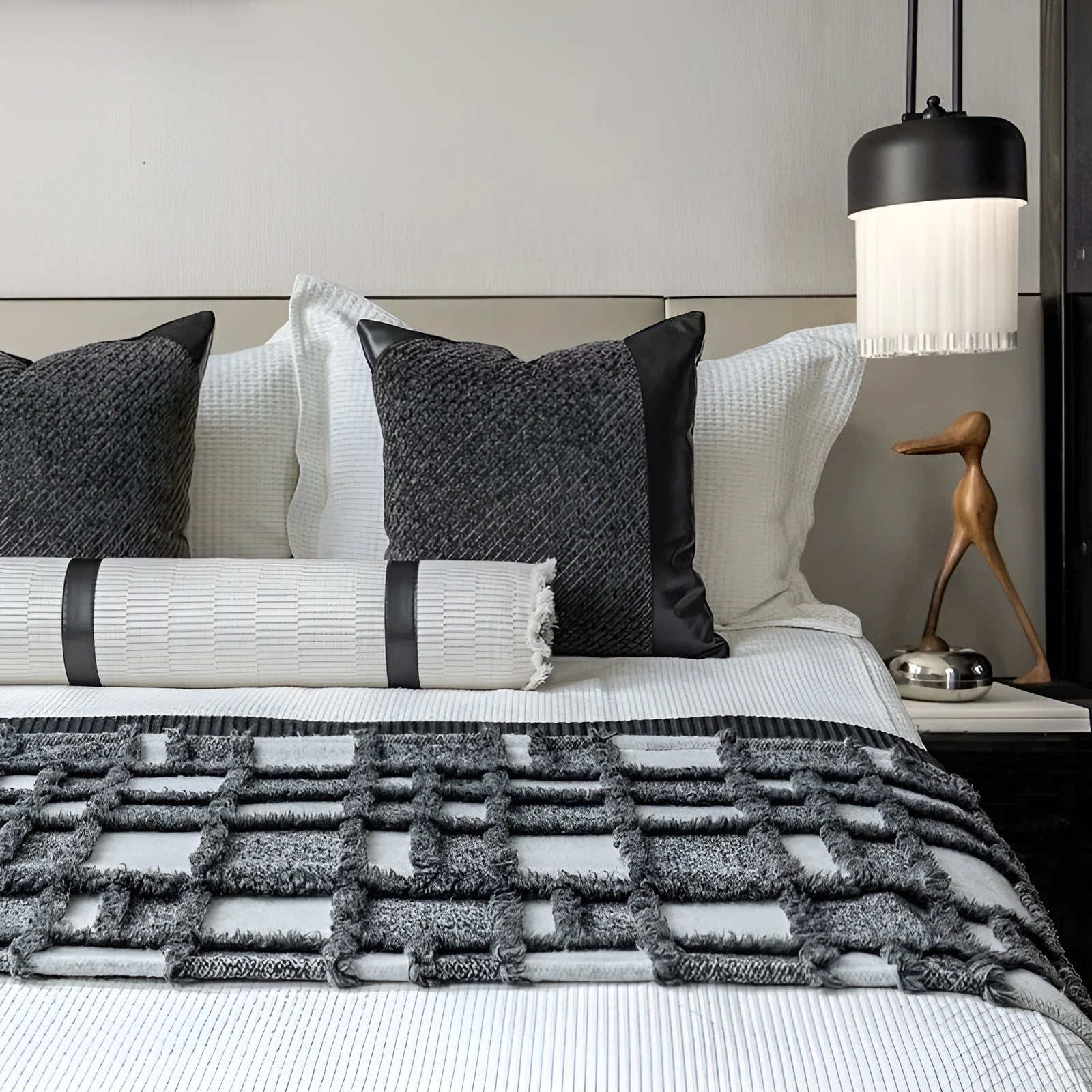 Grey and white plaid polyester bed runner blanket set with matching pillowcase and round leather-look cushion on a bed