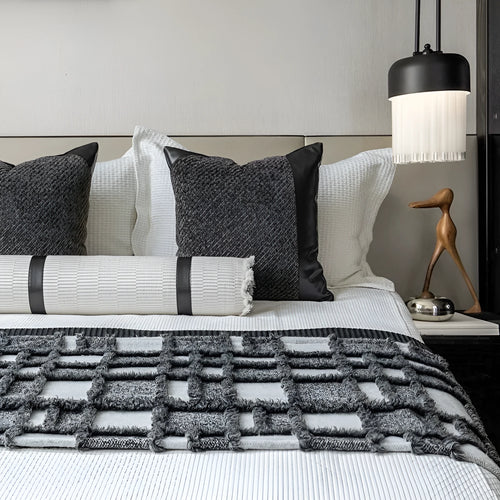 Grey and white plaid polyester bed runner blanket set with matching pillowcase and round leather-look cushion on a bed