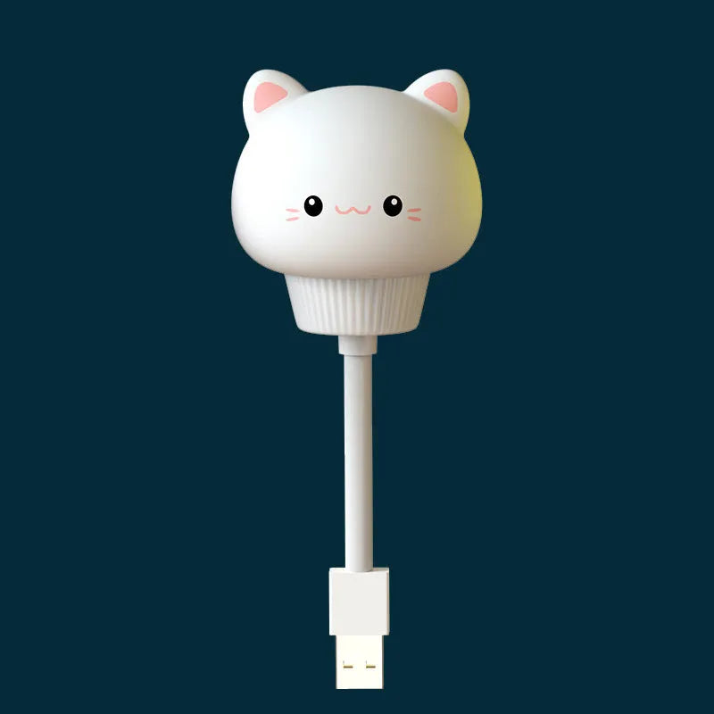 Small cartoon bear-shaped USB night light with remote control on a bedside table.
