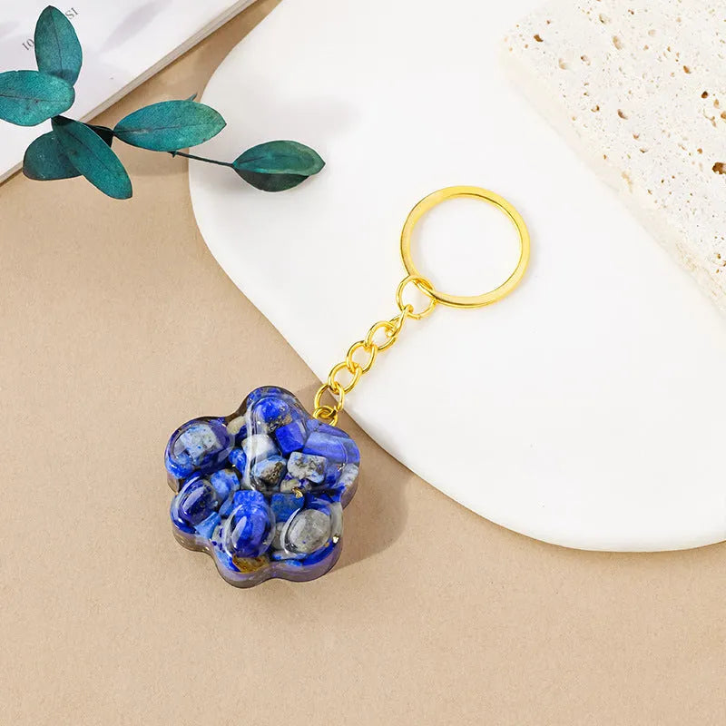 Natural crystal cat's paw shaped pendant on a silver keychain ring, shown in a random colour.