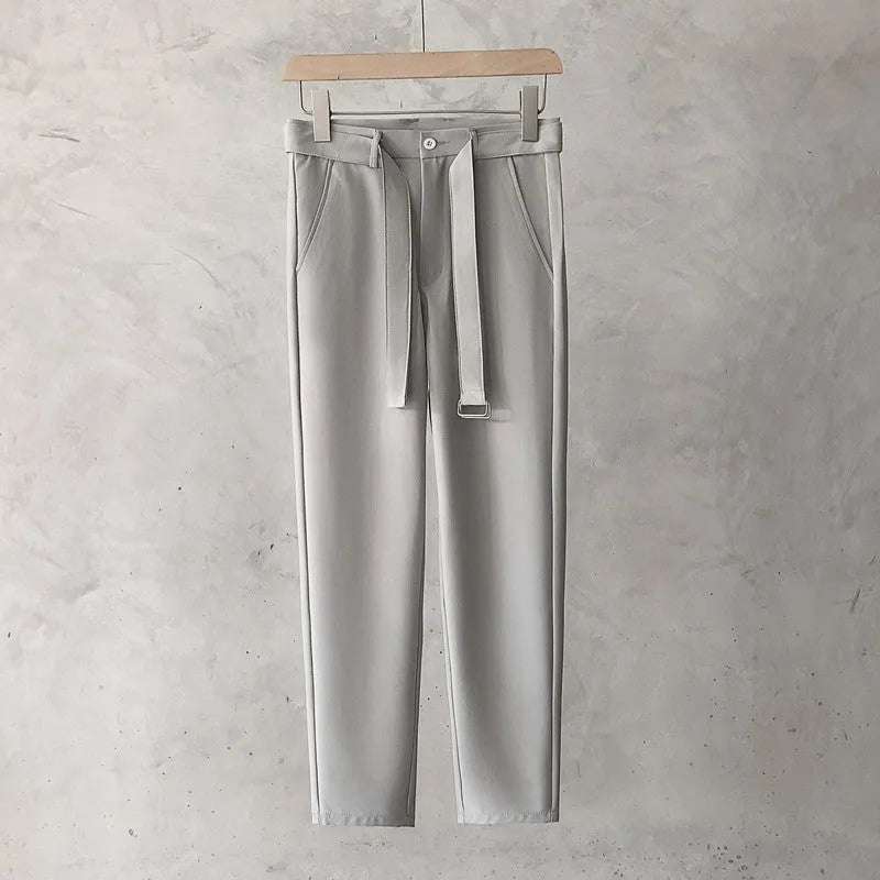 Boy wearing slim straight wool trousers in a neutral colour, showcasing the tapered fit and straight leg opening.