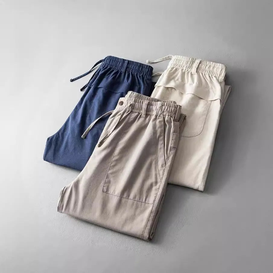 Men's casual linen trousers in solid colour with mid waist design available in navy blue, apricot linen, or grey