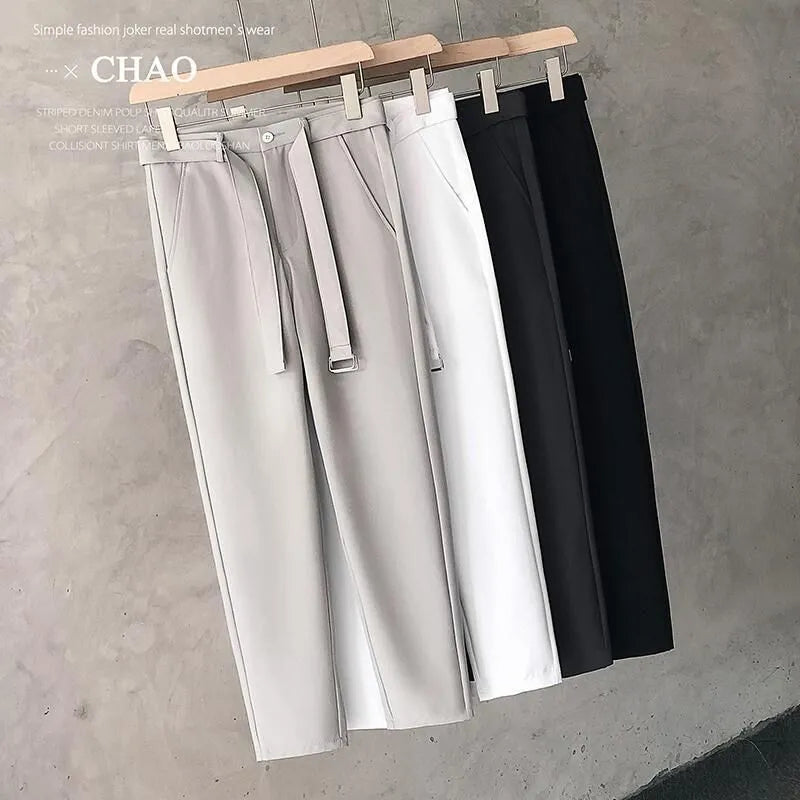 Boy wearing slim straight wool trousers in a neutral colour, showcasing the tapered fit and straight leg opening.