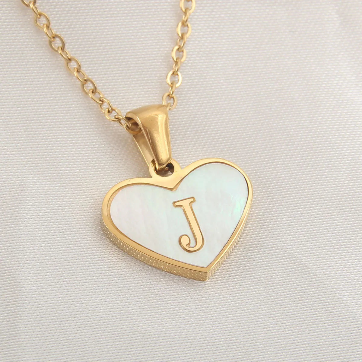 Gold plated heart-shaped necklace with white shell pendant on adjustable stainless steel chain