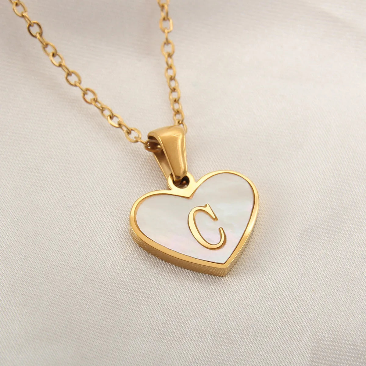Gold plated heart-shaped necklace with white shell pendant on adjustable stainless steel chain