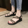 Women's silver flat sandals with rhinestone decoration and elastic strap on a rubber sole.