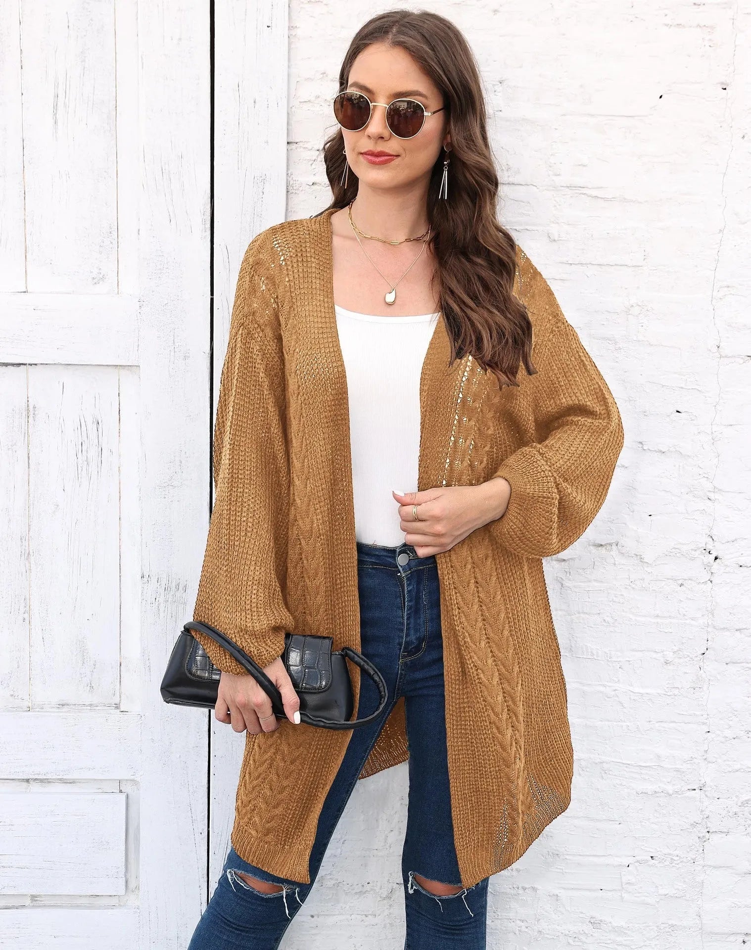 Women's loose brown acrylic sweater coat hanging on a hanger
