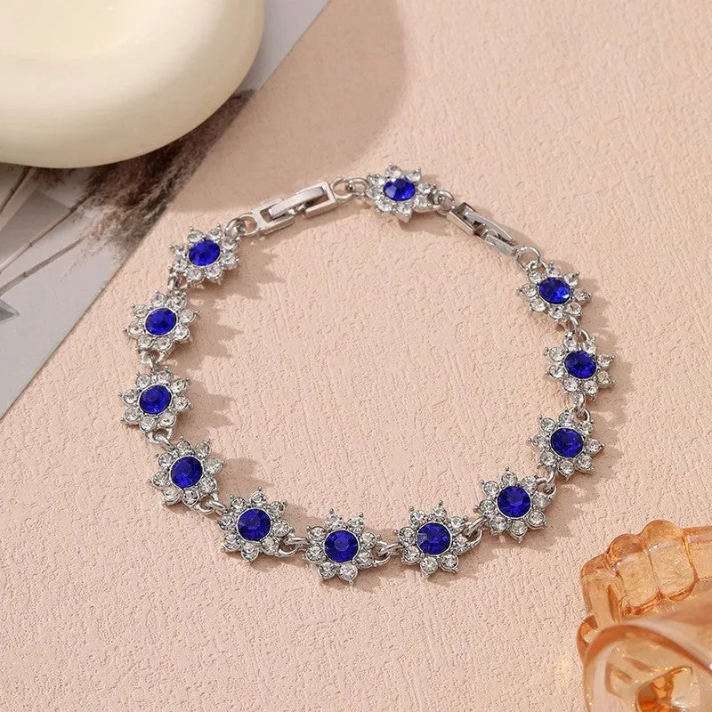 Electroplated zinc alloy flower bracelet in a choice of gold or silver finishes with coloured gemstone designs.