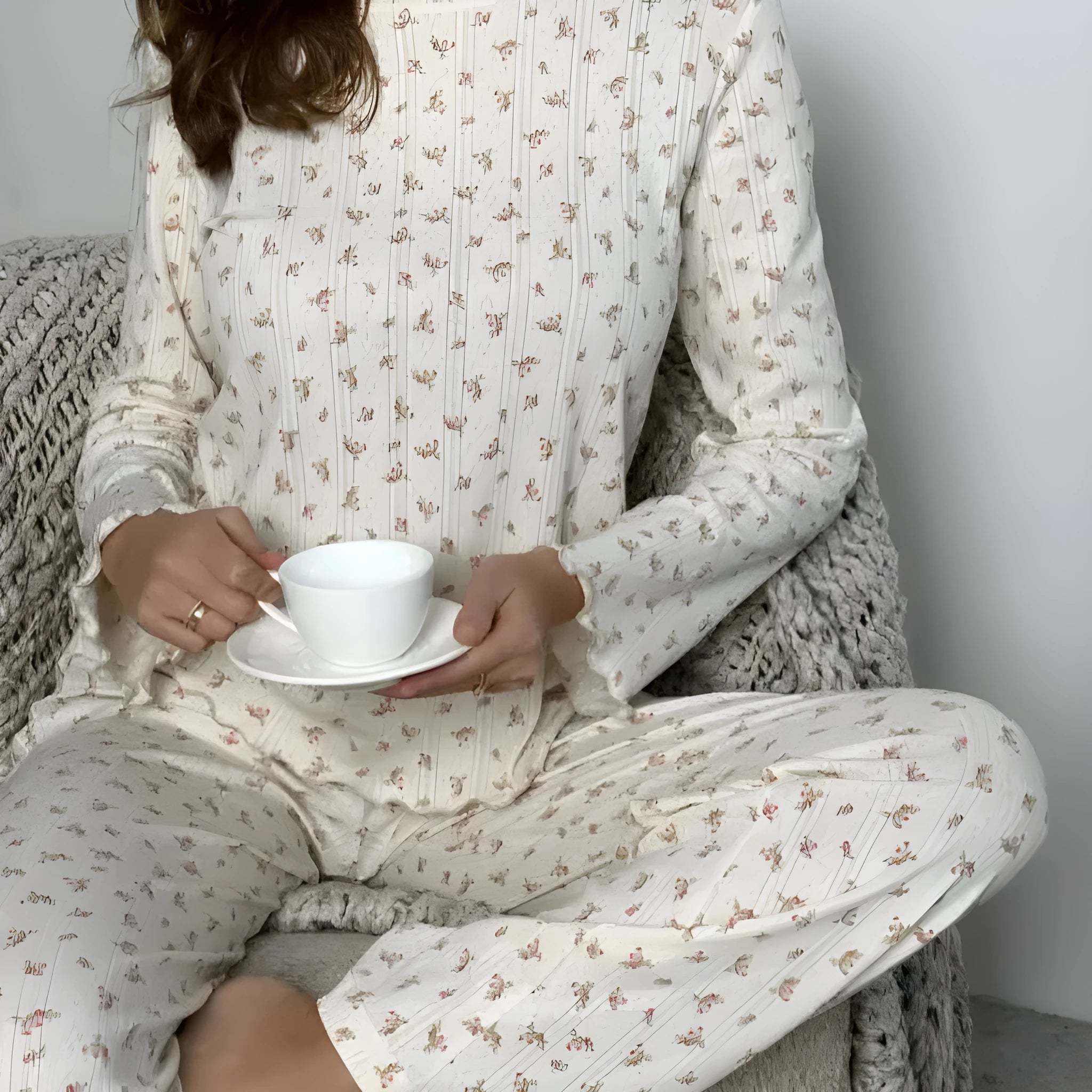 White women's floral print two-piece suit with bell sleeve top and wide-leg trousers on a hanger.