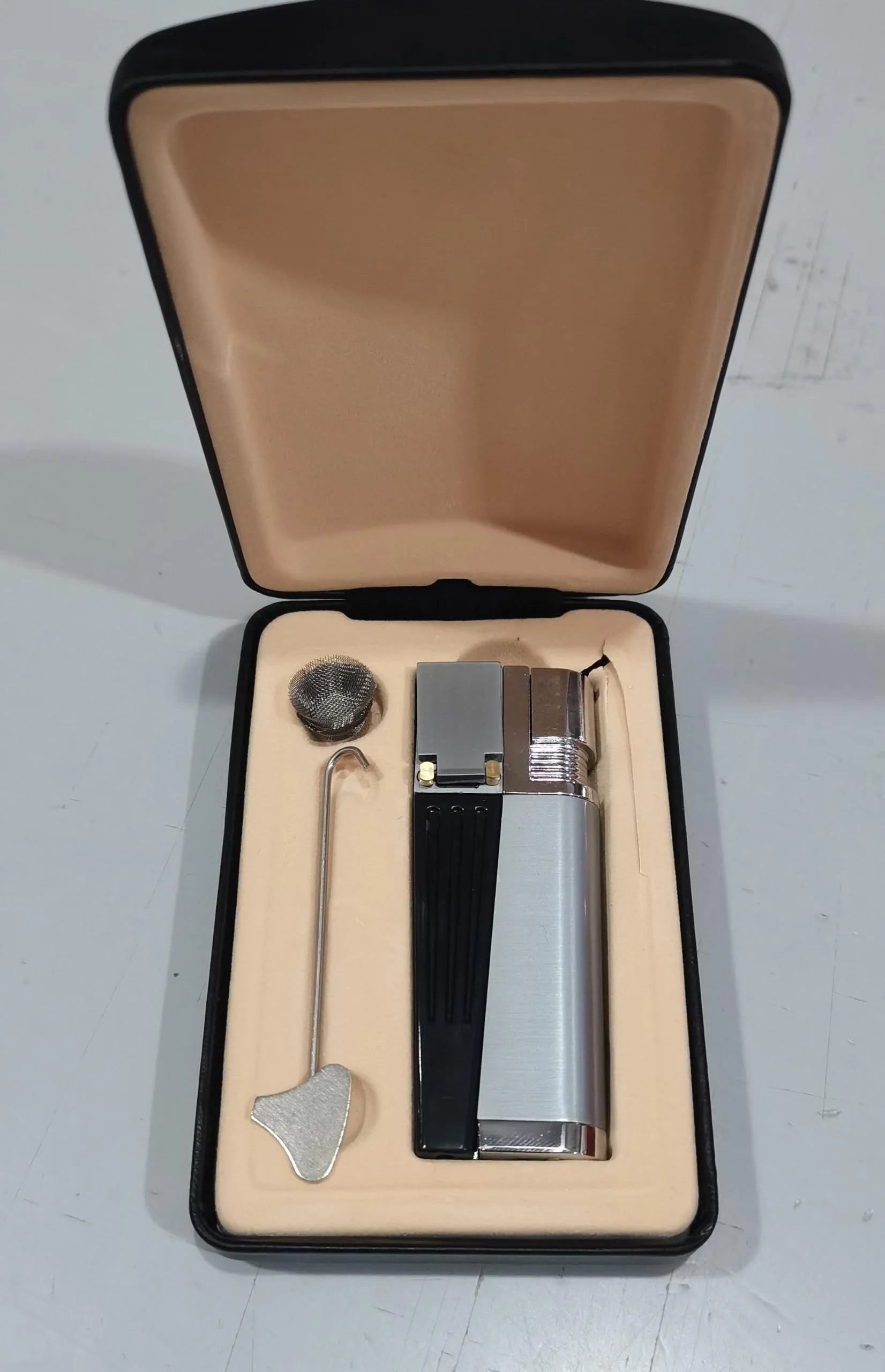 Folding metal pipe lighter showing open position with stash compartment visible