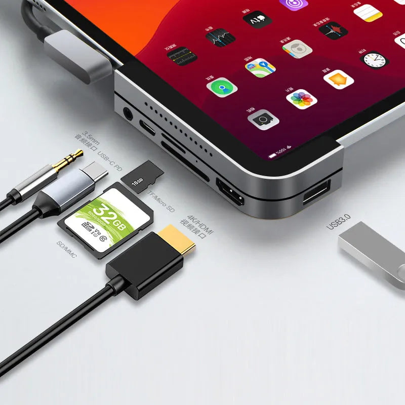 Silver aluminium grey 6-in-1 USB-C docking station for iPad Pro, shown next to a tablet.