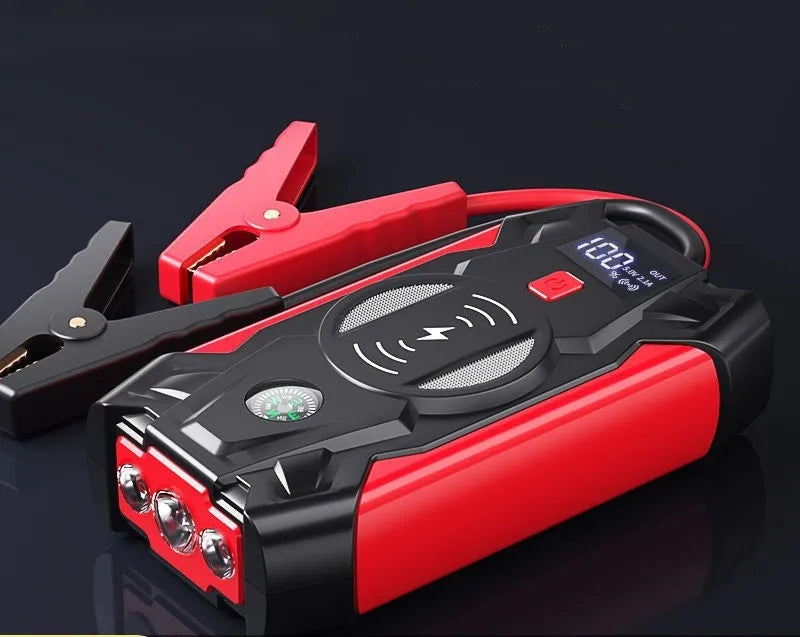 Red portable car jump starter with thick clips and digital display for emergency vehicle battery boosting