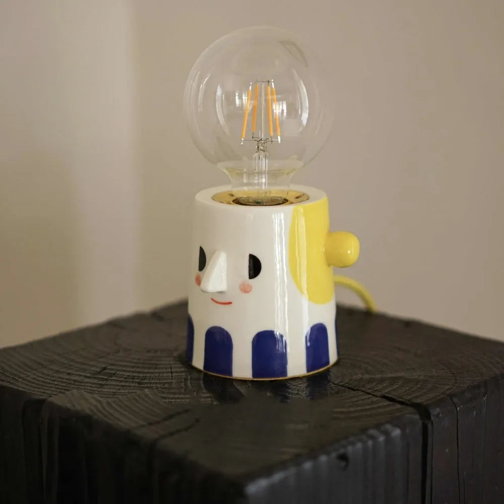 Handmade white ceramic bedside lamp with ball headlight design on wooden table