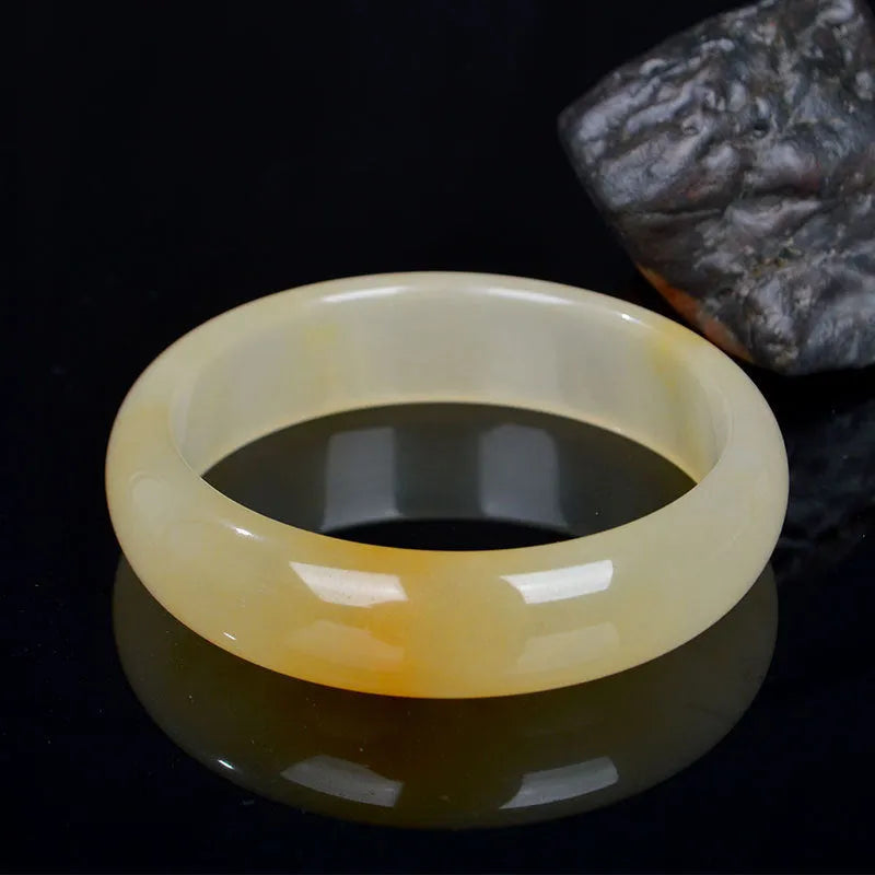 Natural light jade Chinese style bracelet on a white background showing polished finish.