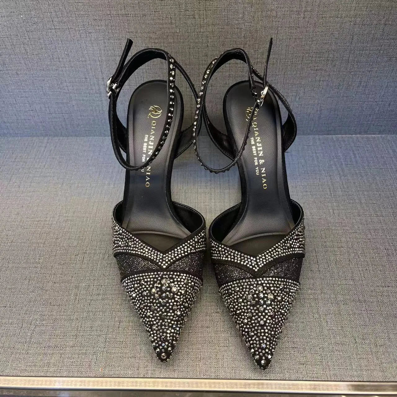 Women's silver hollow stiletto heels with pointed toe and red sole on white background