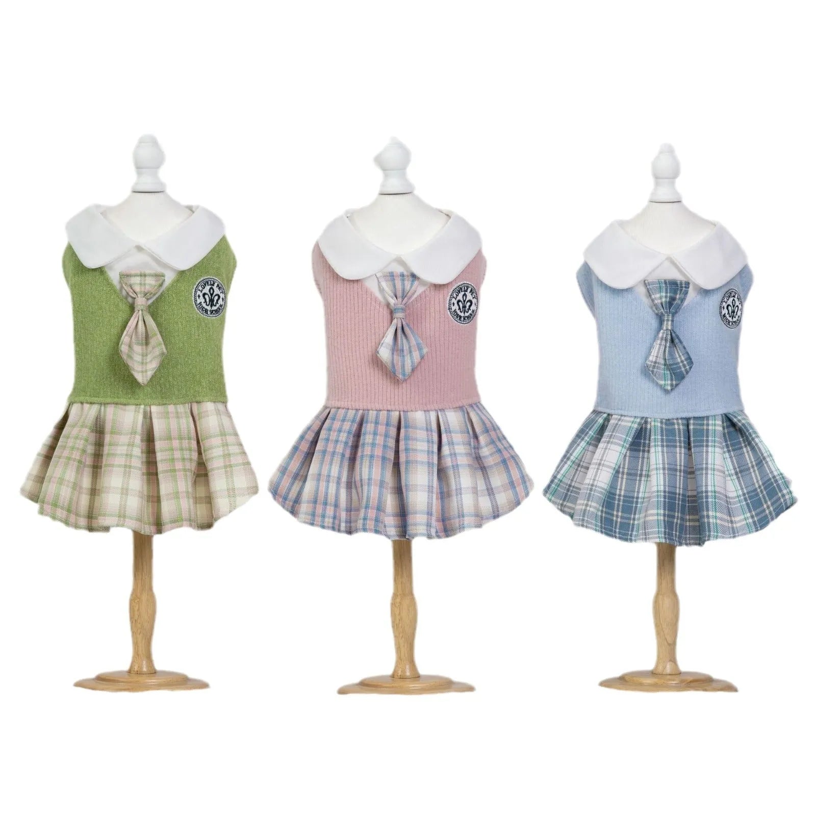A small dog wearing a pink tartan plaid skirt in a Princess style.