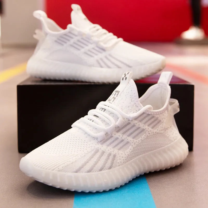 Men's white breathable flying fabric sports shoes with round toe and flat heel on a model.