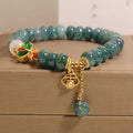 Blue water jade abacus bead bracelet with butterfly charm and white agate on an alloy band.